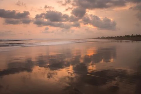Stunning sunset view of orange clouds reflected on the sea in Pangandaran, Java, 库存照片