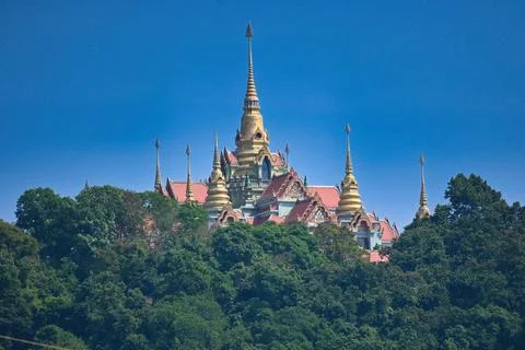 Stunning temple complex sits on a green hill under the blue sky in Thailand.. Stock Photos