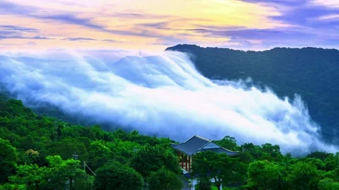 Stunning time lapse of clouds flowing over lush green mountains at sunset. Stock-Footage 341131417