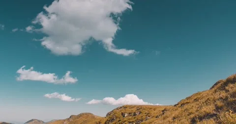 Stunning timelapse view of a mountain range with golden grass under a beautiful Stock Footage 344731030