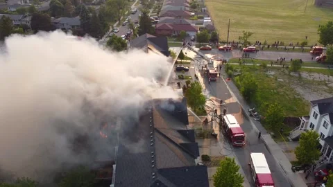 Stunning top view of house burning in flames and firefighters with fire Stock Footage 252925681