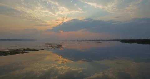 Stunning tracking shot of a beautiful sunset over perfectly calm lake water. Stock Footage 105622665
