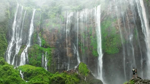 STUNNING Tumpak Sewu Waterfall Java Indonesia Drone Couple Waterfall Base Video stock 305117490