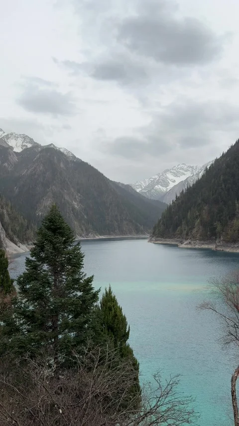Stunning Turquoise Lake Surrounded by Snow Capped Mountains Jiuzhaigou Sichuan Stock Footage 338373315