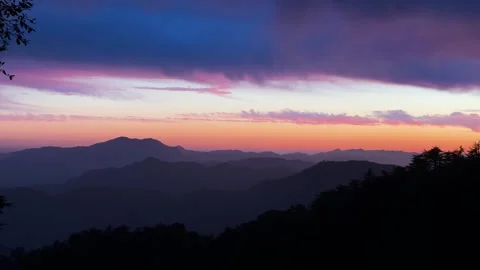 Stunning twilight panorama of rolling mountains beneath dramatic cloud cove.. Stock Footage 336439477