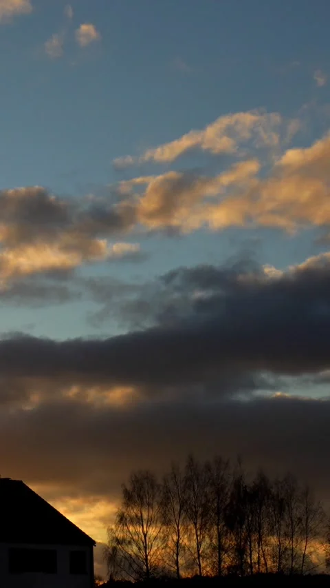 Stunning vertical time-lapse of dynamic clouds moving swiftly across sunset sky Stock Footage 293752815