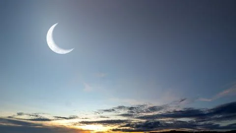 A stunning view of a large, bright crescent moon hanging in the twilight sk.. Ilustração Stock