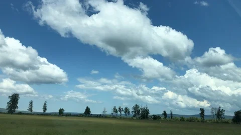Stunning view from the side window of the blue sky in white clouds while dri Stock Footage 124791615