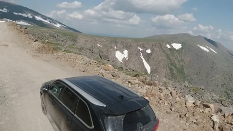 Stunning view of snow-capped mountains and SUV on a mountain road Stock Footage 137439006