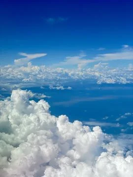 A stunning view through an airplane window, showcasing clear skies and fluf.. Stock Photos