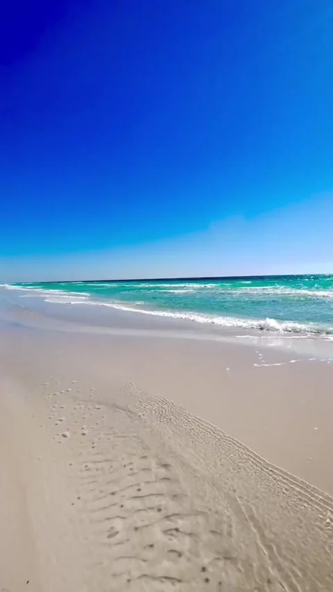 Stunning view of turquoise ocean waves rolling onto a pristine white sand beach Vidéo 334084226