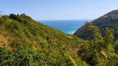 Stunning View of Turquoise Sea Between Green Lush Hills and Coastal Mountain Stock Footage 332136007