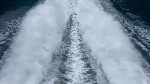 A stunning view of the wake created by a boat gliding through serene blue waters Video stock 313953047