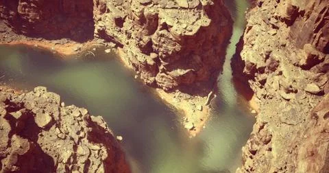 Stunning view of a winding river surrounded by rocky cliffs in a canyon Stock Illustration