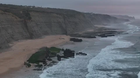 Stunning views of Magoito Beach at twilight with gentle waves and dramatic cliff Stock Footage 283389625