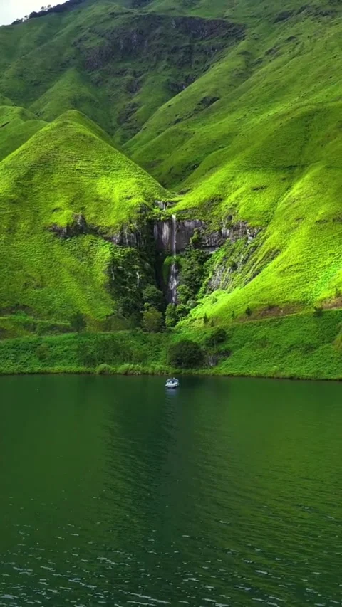 Stunning Waterfall in a Green Valley Flowing into a Calm Lake Stock Footage 310001348