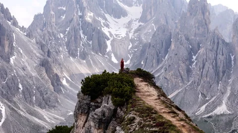 A stunningly beautiful mountain landscape featuring a figure dressed in a Stock Footage 316249089