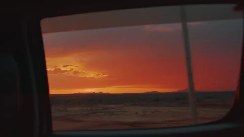 Stunningly beautiful sunset from car window and silhouettes of mountain range on Stockbeeldmateriaal 312724847