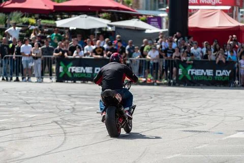 Stunt driver do acrobatics and stunts with his motorbike Stock Photos