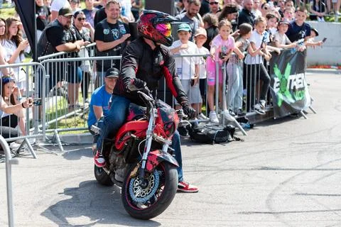 Stunt driver do acrobatics and stunts with his motorbike Stock Photos