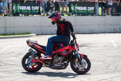 Stunt driver do acrobatics and stunts with his motorbike Stock Photos