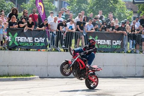 Stunt driver do acrobatics and stunts with his motorbike Stock Photos