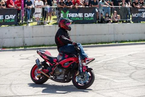 Stunt driver do acrobatics and stunts with his motorbike Stock Photos