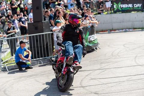 Stunt driver do acrobatics and stunts with his motorbike Stock Photos