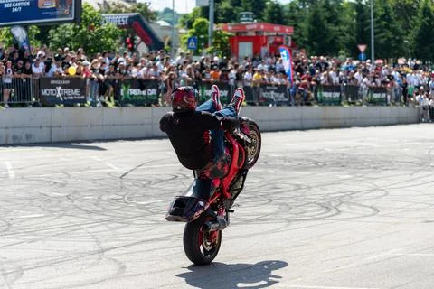 Stunt driver do acrobatics and stunts with his motorbike Stock Photos
