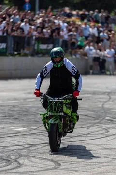 Stunt driver do stunts and acrobatics with his motorbike Stock Photos