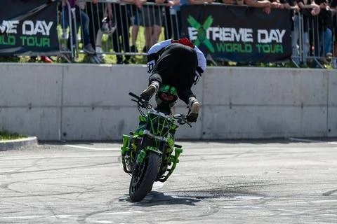 Stunt driver do stunts and acrobatics with his motorbike Stock Photos