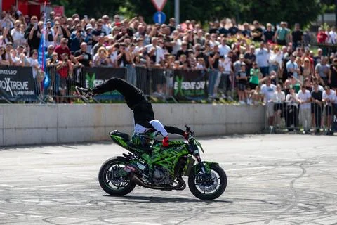 Stunt driver do stunts and acrobatics with his motorbike Stock Photos