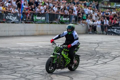 Stunt driver do stunts and acrobatics with his motorbike Stock Photos