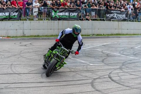 Stunt driver do stunts and acrobatics with his motorbike Stock Photos