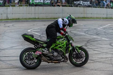 Stunt driver do stunts and acrobatics with his motorbike Stock Photos