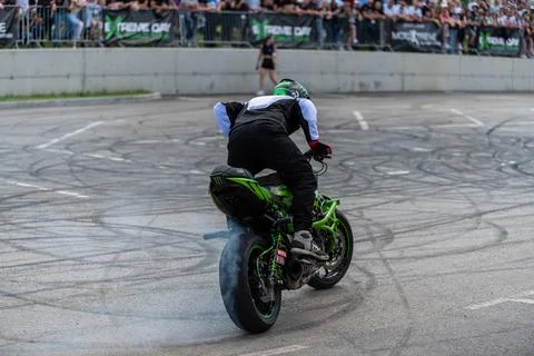Stunt driver do stunts and acrobatics with his motorbike Stock Photos