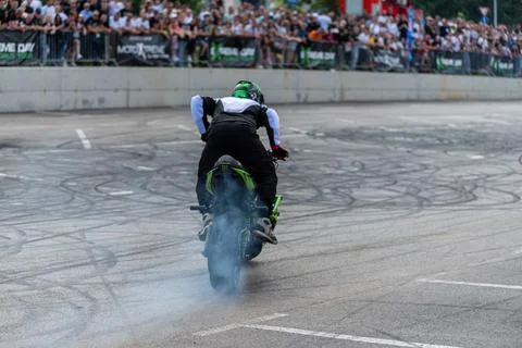Stunt driver do stunts and acrobatics with his motorbike Stock Photos