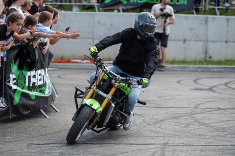 Stunt driver do stunts and acrobatics with his motorbike Stock Photos