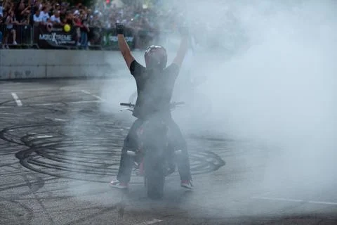 Stunt driver do tire burnout with his motorbike Stock Photos