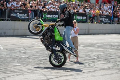 Stunt driver do wheelie around his girlfriend Stock Photos