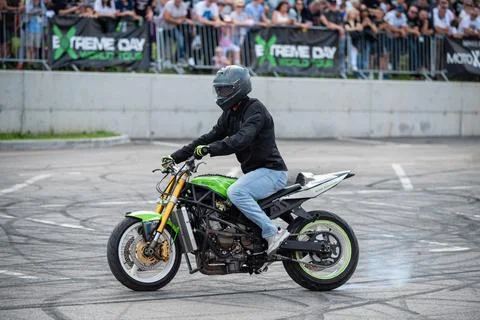 Stunt driver doing acrobatics and stunts with his motorbike Stock Photos