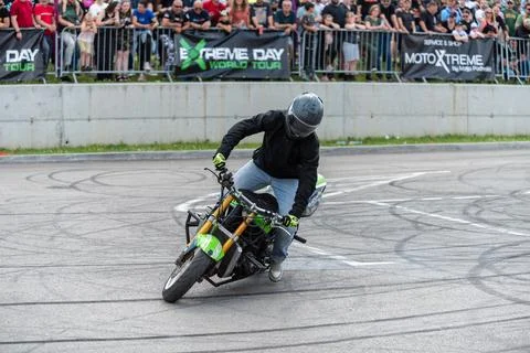 Stunt driver doing acrobatics and stunts with his motorbike Stock Photos