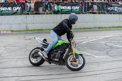 Stunt driver doing acrobatics and stunts with his motorbike Stock Photos