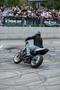 Stunt driver doing acrobatics and stunts with his motorbike Stock Photos