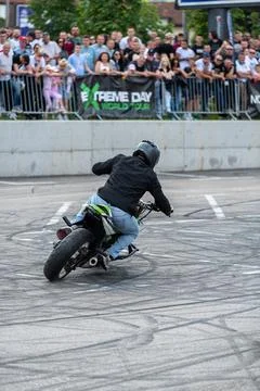 Stunt driver doing acrobatics and stunts with his motorbike Stock Photos