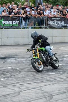 Stunt driver doing acrobatics and stunts with his motorbike Stock Photos