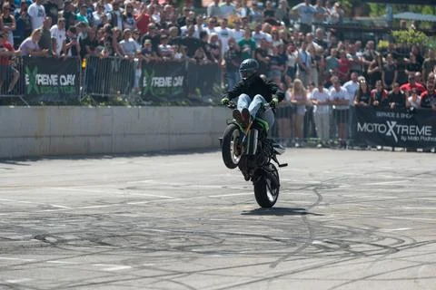 Stunt driver doing acrobatics and stunts with his motorbike Stock Photos