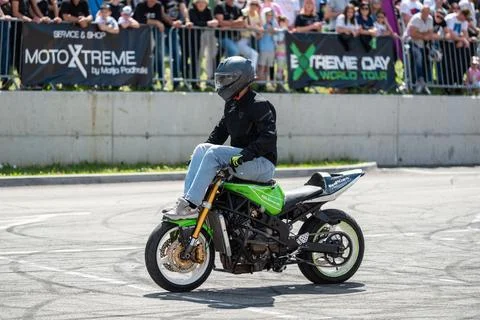 Stunt driver doing acrobatics and stunts with his motorbike Stock Photos