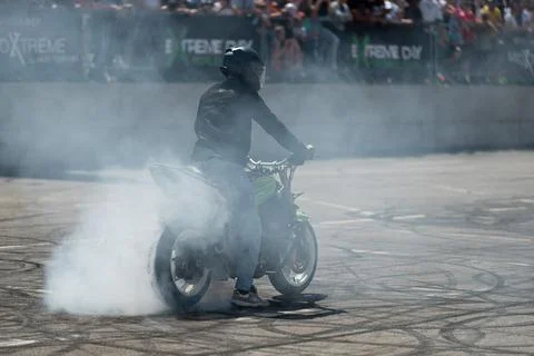 Stunt driver doing burnout stunt with his motorbike Stock Photos