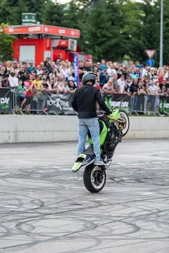 Stunt driver doing wheelie stunts with his motorbike Stock Photos